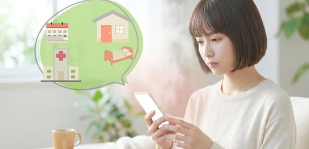 スマートフォンで自分の症状を調べながら、受診すべきか家で様子をみてもいいか考えている様子